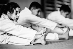Coed youth students stretching in karate class