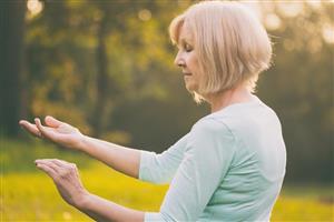 Older woman practicing tai chi in the park